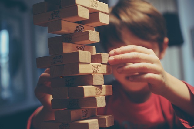 A kid is playing with jenga tiles.