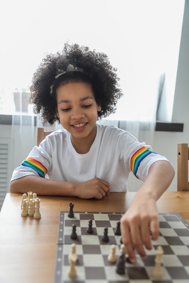 Little girl is playing chess.